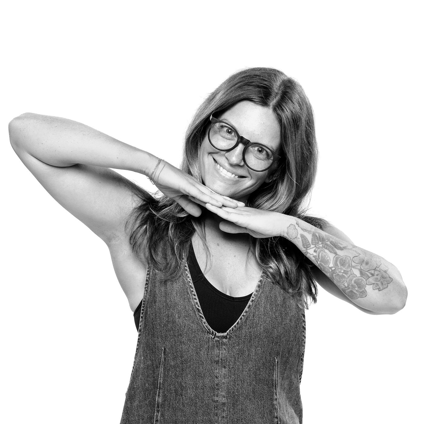 Black-and-white portrait of Vanessa Airey smiling with her hands beneath her chin.